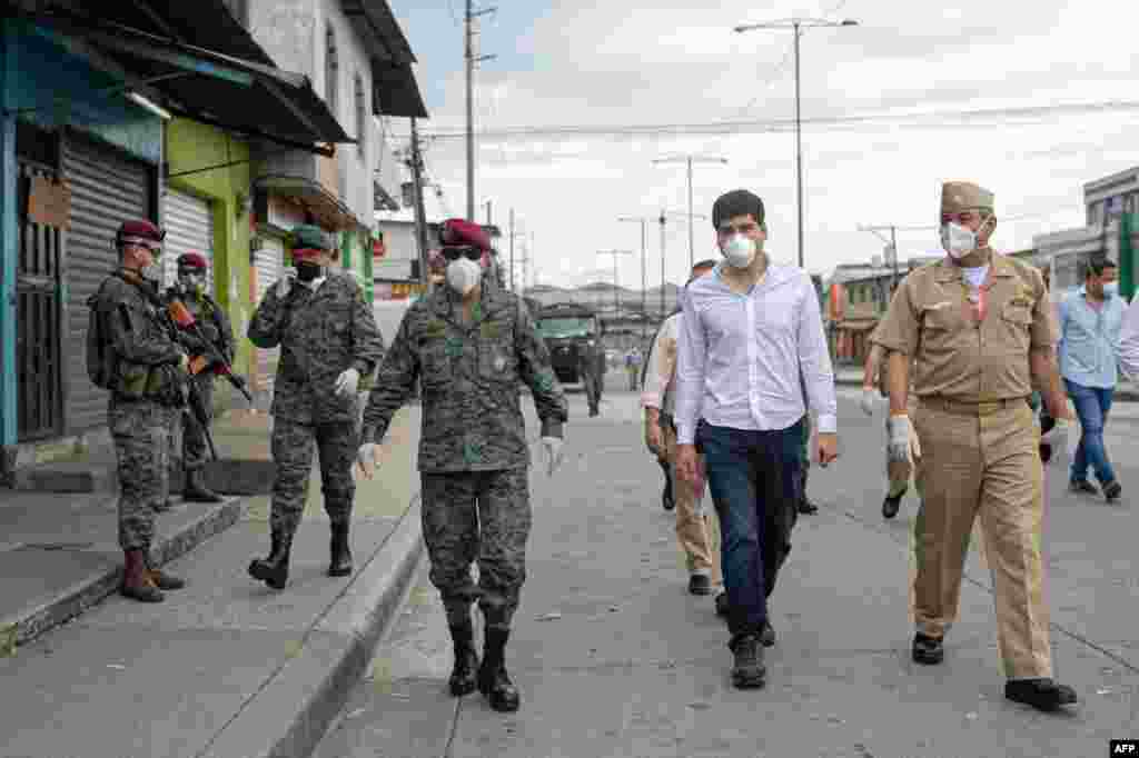 Folleto publicado por el Secretario de Comunicación de Ecuador que muestra al Vicepresidente ecuatoriano Otto Sonnenholzner (C) y al Comandante en Jefe de las Fuerzas Armadas Luis Lara (L) caminando en las calles de Guayaquil el 3 de abril de 2020, durante la cuarentena en Ecuador debido a la pandemia.