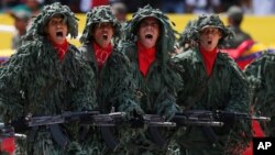 Miembros de un batallón de francotiradores venezolanos participan en el defile conmemorativo del primer aniversario de la muerte de Hugo Chávez.