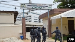 Police officers walk out of premises of the Autonomous National Electoral Commission (CENA) as counting of votes begins in Cotonou, on Apr. 12, 2021. 