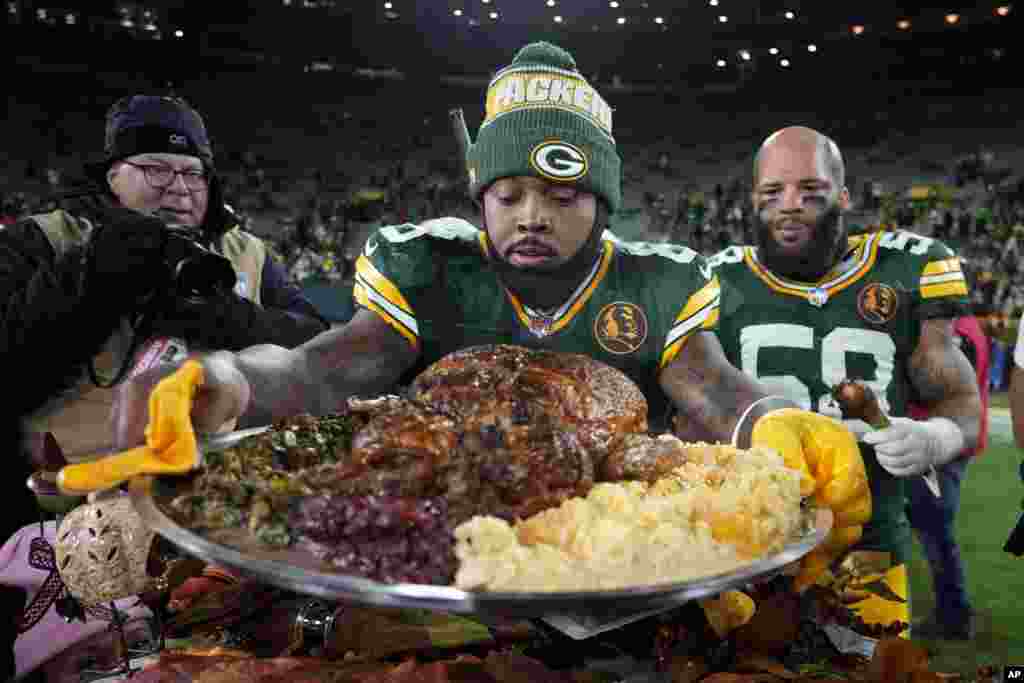 Green Bay Packers running back Josh Jacobs holds a plate of turkey after an NFL football game against the Miami Dolphins, Nov. 28, 2024, in Green Bay, Wisconsin.