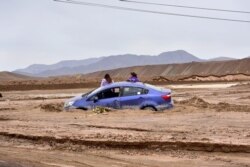 FILE - A car is trapped in mud due to floods near a copper mine in Chuquicamata, Chile, Feb. 7, 2019.