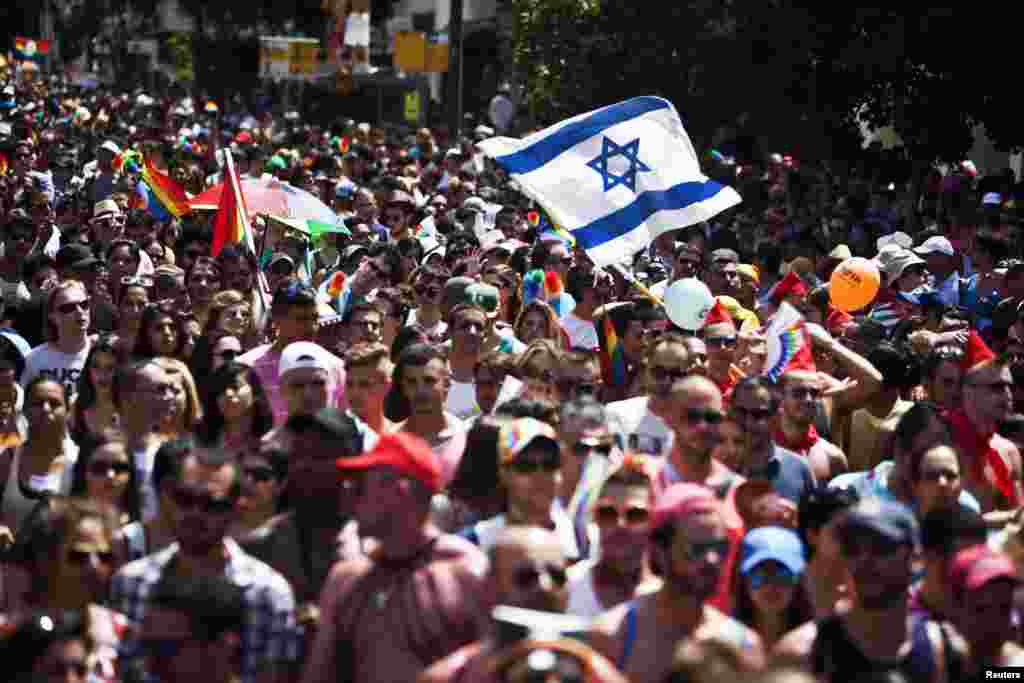 People take part at the annual Gay Pride parade in Tel Aviv. Thousands of revelers paraded on the streets of Israel&#39;s free-wheeling city, which has become a Mediterranean hotspot for gay tourism.