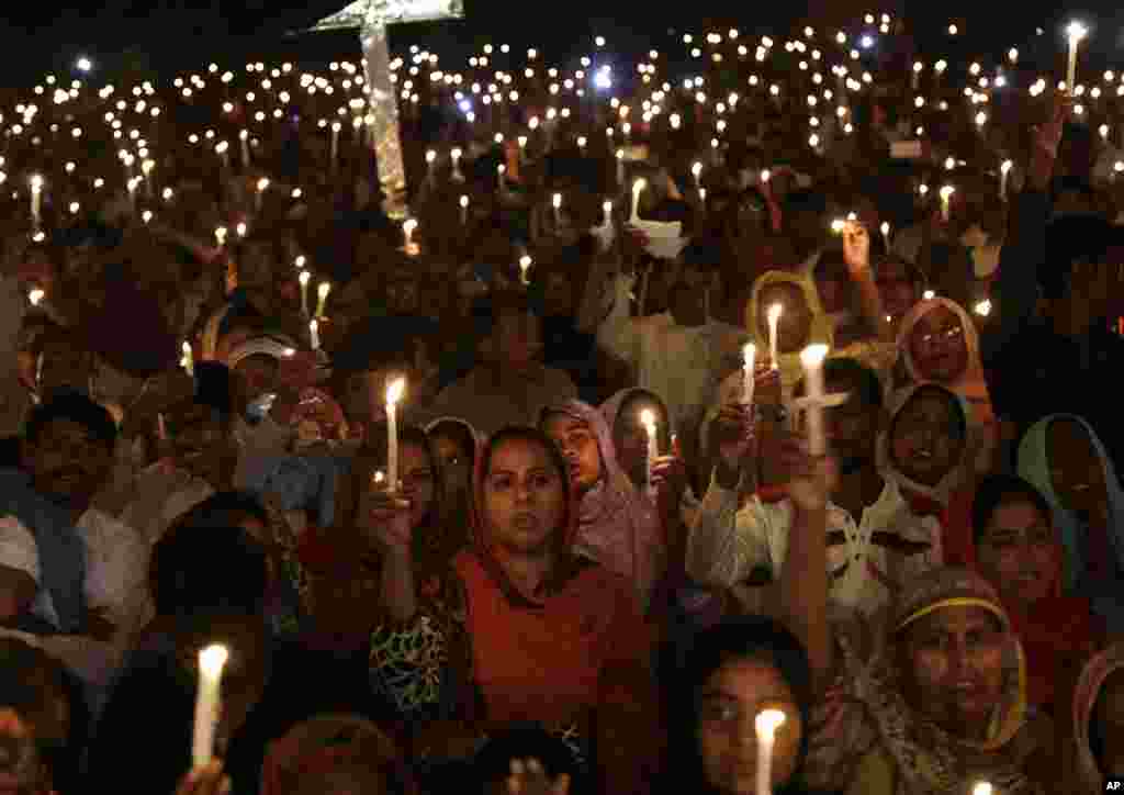 Pakistani Christians hold candles during a vigil for victims of a deadly suicide bombing last Sunday, in Lahore.
