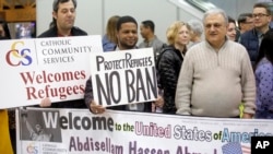 Refugee supporters look on after Abdisellam Hassen Ahmed, a Somali refugee who had been stuck in limbo after President Donald Trump temporarily banned refugee entries, arrives at Salt Lake International Airport, in Salt Lake City, Feb. 10, 2017.