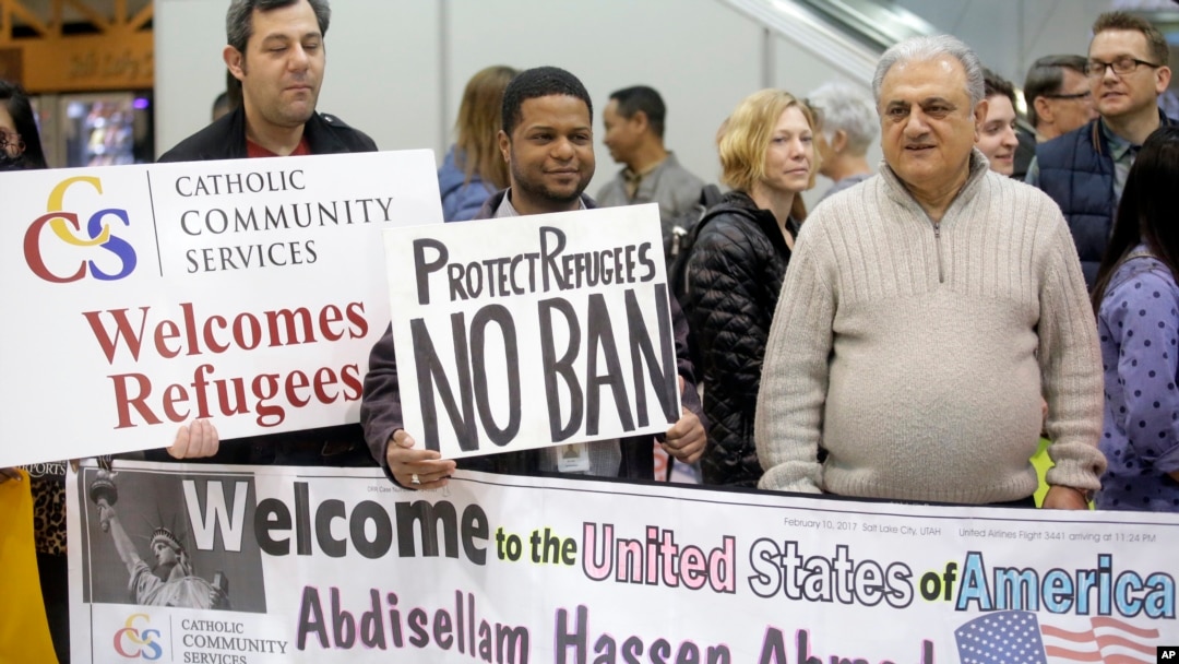 Refugee supporters look on after Abdisellam Hassen Ahmed, a Somali refugee who had been stuck in limbo after President Donald Trump temporarily banned refugee entries, arrival at Salt Lake International Airport, in Salt Lake City, Feb. 10, 2017. 