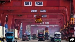 FILE - Containers are unloaded from a cargo ship at Qingdao Port, east China's Shandong Province, Feb. 11, 2024, in this photo released by Xinhua News Agency. 