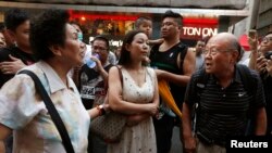 A pro-democracy protester, right, argues with an anti-Occupy resident, left, on Nathan Road blocked by pro-democracy protesters at Mongkok shopping district in Hong Kong, Oct. 20, 2014. 