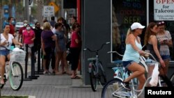 FILE - People stand in line at a Duval County restaurant by the beach after it was opened amid coronavirus disease (COVID-19) restrictions in Jacksonville, Florida, April 19, 2020. 