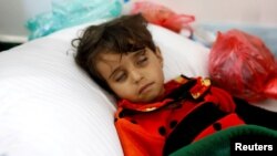 FILE - A girl infected with cholera lies on the ground at a hospital in Sana'a, Yemen, May 7, 2017.
