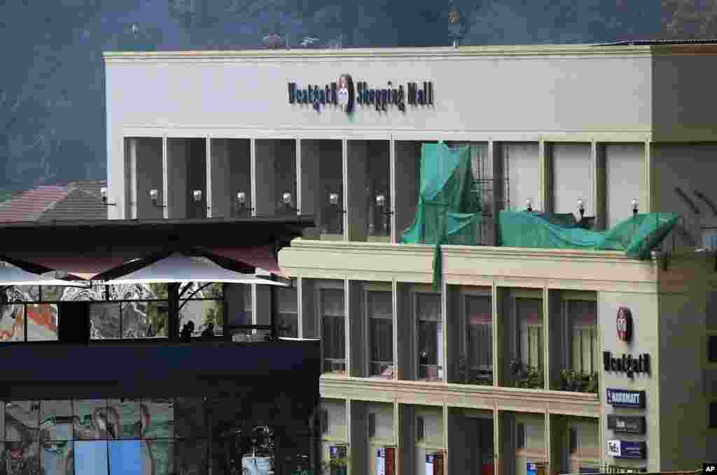 Kenyan security forces stand on the top floor of a building facing the Westgate Mall in Nairobi, Sept. 25, 2013.