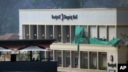 Kenyan security forces stand on the top floor of a building facing the Westgate Mall in Nairobi, Kenya, Wednesday Sept. 25, 2013. Gunshots rang out from the mall Wednesday morning, the day after the president declared an end to a four-day siege by Islamic