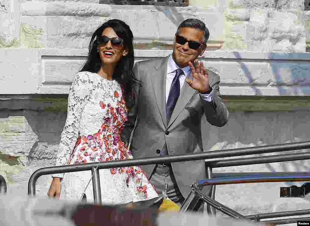 U.S. actor George Clooney and his wife Amal Alamuddin leave the seven-star hotel Aman Canal Grande Venice in Venice, Italy, Sept. 28, 2014.