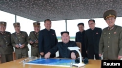 Pemimpin Korea Utara Kim Jong Un saat mengamati uji coba peluncuran rudal balistik jarak jauh dan menengah di Pyongyang. (30/8/17)