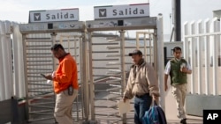 Carlos Catarldo Gomez, dari Honduras (tengah), dikawal oleh pejabat Meksiko setelah meninggalkan Amerika Serikat, orang pertama kembali ke Meksiko untuk menunggu tanggal persidangan suaka di Tijuana, Meksiko, 29 Januari 2019. (Foto: dok).