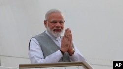 FILE - Indian Prime Minister Narendra Modi greets as he disembarks from the aircraft upon his arrival in Colombo, Sri Lanka, Thursday, May 11, 2017.
