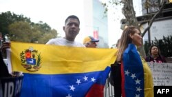 Los partidarios de la oposición venezolana sostienen pancartas y carteles en protesta, en la sede de las Naciones Unidas en la ciudad de Nueva York. 