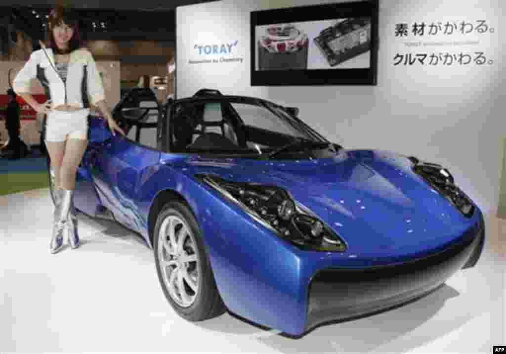 A model poses by Toray's concept Electric Vehicle (EV) "TEEWAVE AR1" at the Tokyo Motor Show in Tokyo, Wednesday, Nov. 30, 2011. (AP Photo/Koji Sasahara)