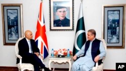 In this photo released by the Press Information Department, Pakistani Foreign Minister Shah Mahmood Qureshi, right, meets visiting British Home Secretary Sajid Javid at the Foreign Ministry in Islamabad, Pakistan, Monday, Sept. 17, 2018. Javid said Monday that the eradication of corruption is a priority for both countries and announced a new partnership between them that would strive for "justice and accountability."