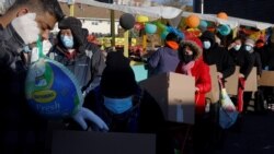 Residents receive free groceries, including a turkey, distributed by La Colaborativa, who gave out food for 3500 people over the course of the day, ahead of the Thanksgiving holiday in Chelsea, Massachusetts, Nov. 23, 2021.