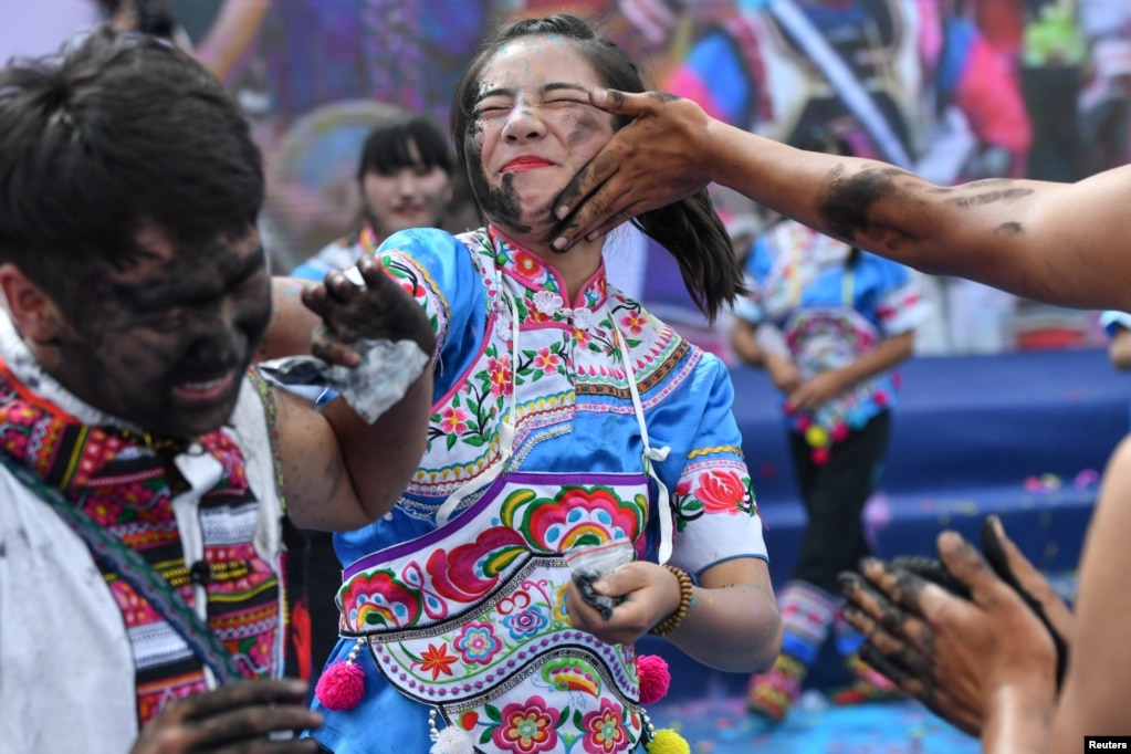 在云南丘北县的彝族传统节日，人们互相在脸上抹灰，以表示祝你好运。（2017年7月18日）