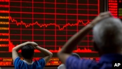 Investors monitor a display showing the Shanghai Composite Index at a brokerage in Beijing, Aug. 31, 2015. 