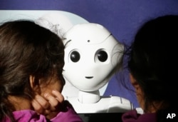 Two young sisters get to know Pepper the robot at Westfield Mall in San Francisco, Dec. 22, 2016.