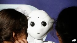 Two young sisters get to know Pepper the robot at Westfield Mall in San Francisco, Dec. 22, 2016.