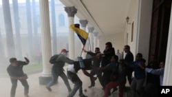 Patizan Prezidan Nicolas Madulo yo nan moman yo tap pote boure nan palman Venezuela a ki anba kontwòl opozisyon an, kote yo te atake legislatè yo ki te an dedan an e kenbe an otaj plizyè santèn moun nan building nan pandan 9 vèd tan.