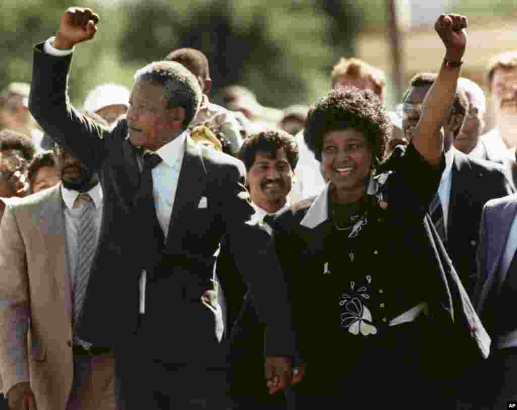 In this Feb. 11, 1990, file photo Nelson Mandela and wife Winnie, walking hand in hand, raise clenched fists upon his release from prison in Cape Town, South Africa. 