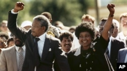 DOSSIER – Dans cette photo du 11 février 1990, Nelson Mandela et sa femme Winnie, marchant main dans la main, lèvent les poings serrés à sa sortie de prison au Cap, en Afrique du Sud.