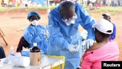 FILE - A Congolese health worker administers Ebola vaccine to a woman who had contact with an Ebola sufferer in the Democratic Republic of Congo, Aug. 18, 2018. Scientists now say they have a treatment for those ill with the deadly virus.