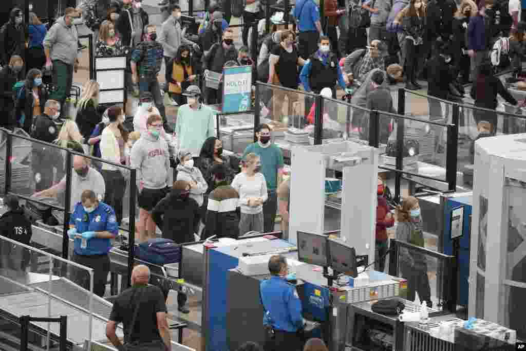 Travelers check at the south security checkpoint as traffic increases as the Thanksgiving holiday nears, Nov. 23, 2021, at Denver International Airport in Denver, Colorado.