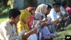 Warga membacakan ayat-ayat suci Al-Qur'an saat berziarah di kuburan massal para korban tsunami dalam peringatan 15 tahun bencana tersebut di Banda Aceh, 26 Desember 2019. 