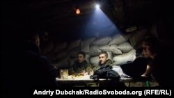 Вечеря під час бою. Українські військові вечеряють у бліндажі на передовій під Попасною, у той час, як інші бійці придушували вогонь противника