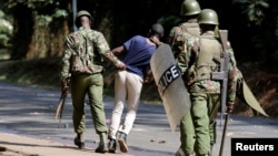 Riot policemen arrest a student of the University of Nairobi during a protests in Nairobi, Kenya, Sept. 28, 2017. 