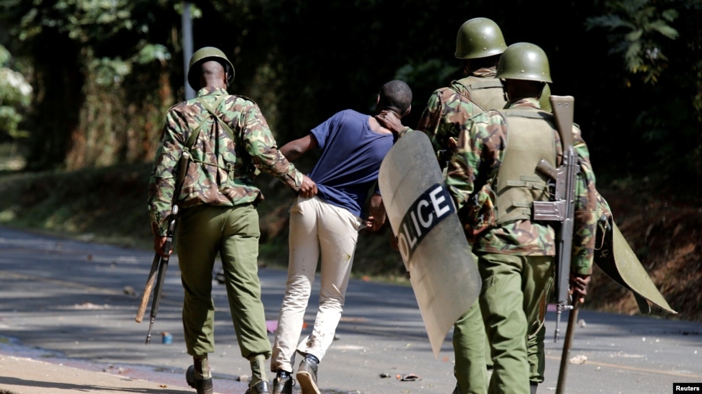 Polisi wa kupambana na ghasia wakimkamata mwanafunzi wa chuo kikuu cha Nairobi. 