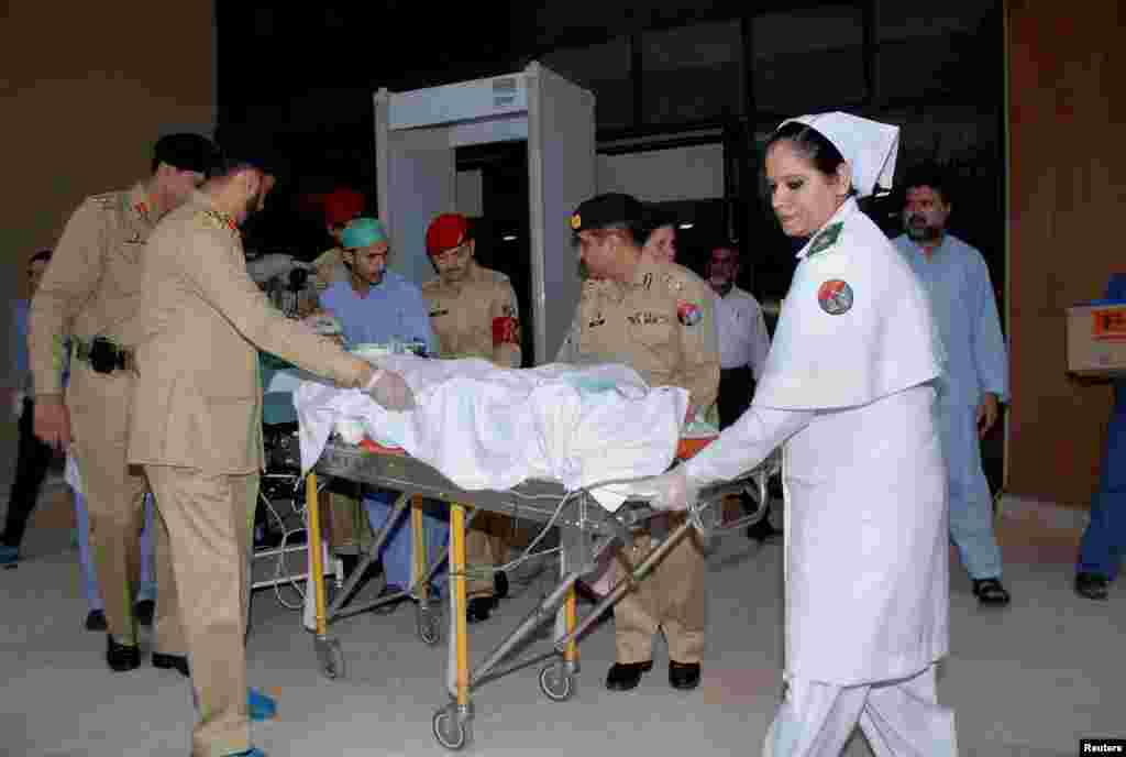 Malala Yousufzai is brought out of a hospital on a stretcher in Rawalpindi before being flown to the United Kingdom for medical treatment.