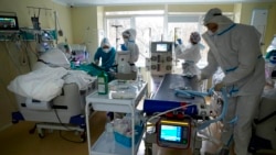 Médicos con trajes especiales atienden a un paciente con COVID-19 en un hospital de Moscú, Rusia, el 19 de octubre de 2021.