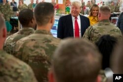 FILE - President Donald Trump and first lady Melania Trump visit with members of the military at a dining hall at Al Asad Air Base, Iraq, Dec. 26, 2018.