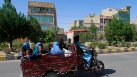 Afghan women and children travel in a motorcycle cart during fighting between Taliban and Afghan security forces in Herat province, west of Kabul, Afghanistan, Sunday, Aug. 1, 2021. (AP Photo/Hamed Sarfarazi)