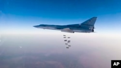FILE - In this frame grab from video provided by the Russian Defense Ministry Press Service, Russian long range bomber Tu-22M3 flies during a strike above an undisclosed location in Syria on Aug. 14, 2015.