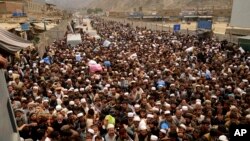FILE - Afghan nationals prepare to cross the Torkham border post in Pakistan en route to Afghanistan, March 7, 2017. 