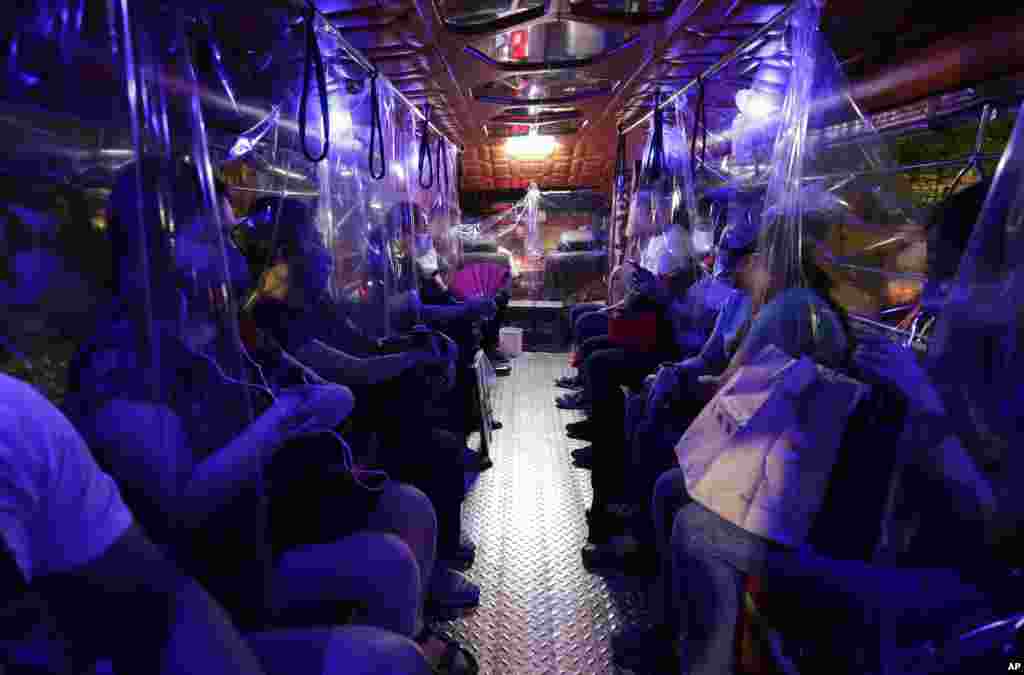 Plastic sheets on a traditional Jeepney bus separate passengers as part of health measures to help prevent the spread of the new coronavirus in metropolitan Manila, Philippines.