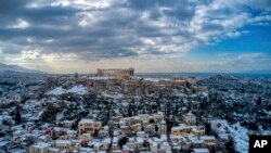 Bukit Acropolis kuno dan distrik tradisional Plaka, kawasan wisata populer di Athena, tertutup salju, Rabu, 17 Februari 2021. (Antonis Nikolopoulos/Eurokinissi via AP)