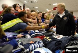 U.S. President Donald Trump greets volunteers who have sorted donated clothing at the Providence Baptist Church in Beauregard, Alabama, March 8, 2019.