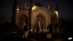 Taliban fighters walk at the entrance of the Eidgah Mosque after an explosion in Kabul, Afghanistan, Oct. 3, 2021. 