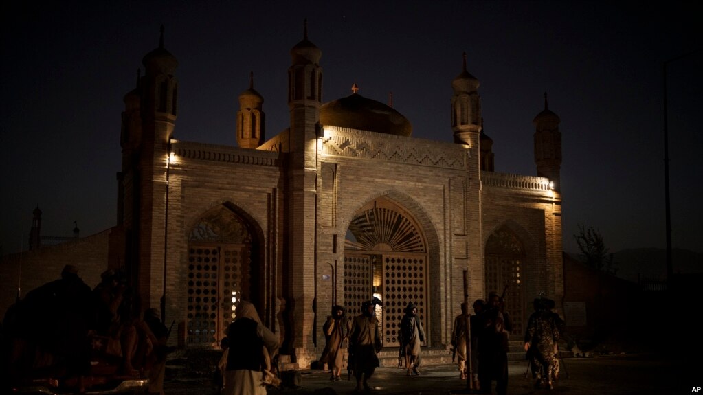 Taliban fighters walk at the entrance of the Eidgah Mosque after an explosion in Kabul, Afghanistan, Oct. 3, 2021. 