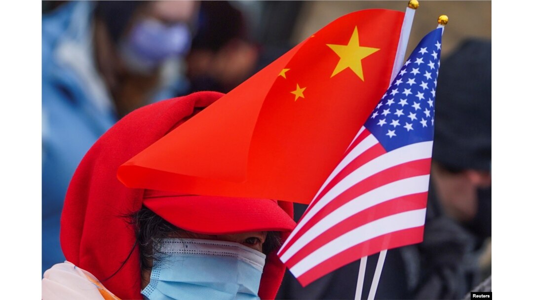 Seseorang memegang bendera AS dan China saat perayaan Tahun Baru Imlek Kota New York ke-22, di kawasan Pecinan di wilayah Manhattan di Kota New York, New York, AS, 12 Februari, 2021. (Foto: REUTERS/Carlo Allegri)