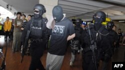 Polisi khusus anti teror Densus 88 saat menangkap tersangka teroris yang baru tiba di bandara Jakarta (foto: dok). Polisi menahan dua pria terkait rencana serangan bunuh diri perayaan Tahun Baru 2016 di Jakarta.