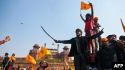 Nông dân Ấn phá rào chắn và tiến vào cắm cờ trên Pháo đài Đỏ ở thủ đô New Delhi vào ngày 26/1/2021.